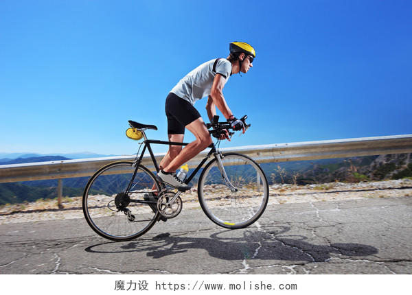 脚踏单车的男子骑一辆自行车上坡沿着一条路 明确夏季的一天青春活力
